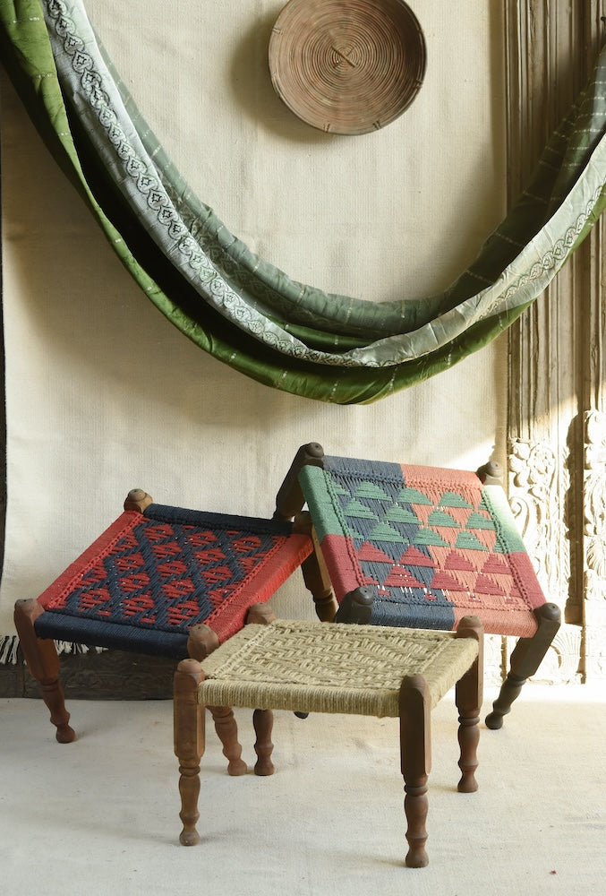Handcrafted charpai-inspired wooden stool with handwoven cotton seat, featuring traditional Indian weaving and vibrant patterns by Ekaurr
