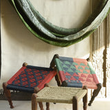 Handcrafted charpai-inspired wooden stool with handwoven cotton seat, featuring traditional Indian weaving and vibrant patterns by Ekaurr