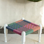 Handcrafted charpai-inspired wooden stool with handwoven cotton seat, featuring traditional Indian weaving and vibrant patterns by Ekaurr