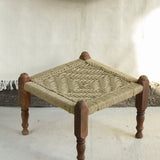 Handcrafted charpai-inspired wooden stool with handwoven cotton seat, featuring traditional Indian weaving and vibrant patterns by Ekaurr
