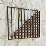 Close-up of Ekaurr Abacus Wall Art showing worn wooden spool textures and metal frame detail – artisanal nostalgic decor