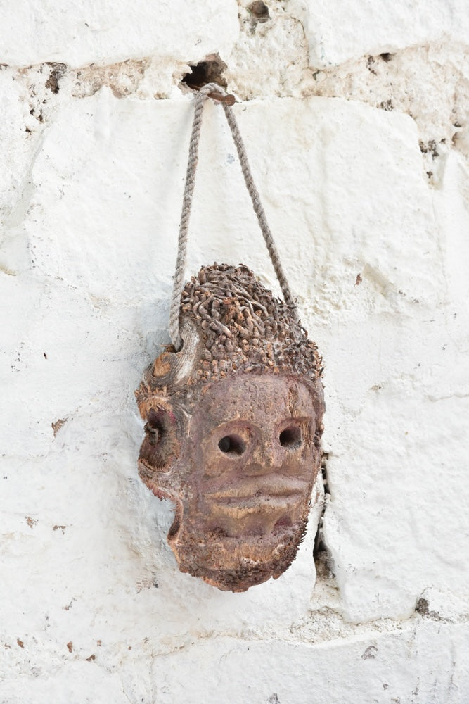 Close-up detail of Ekaurr Ancestral Echo wall mask showing hand-carved surface texture and aged earthy finish
