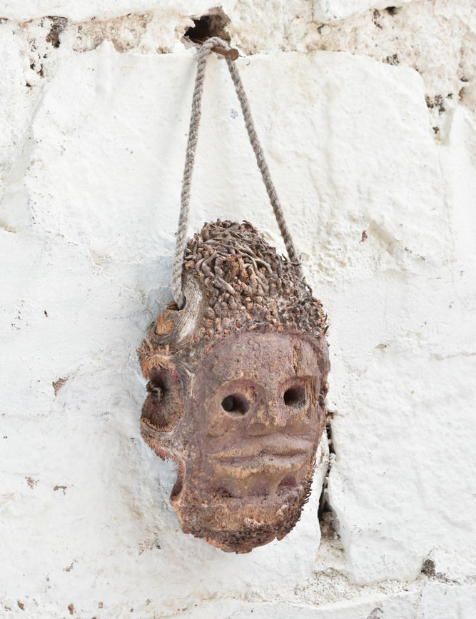 Close-up detail of Ekaurr Ancestral Echo wall mask showing hand-carved surface texture and aged earthy finish