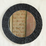 Ekaurr Artisan Wooden Emblem Round Mirror with sculptural border of black-finished carved wooden emblem blocks showing abstract motifs and typographic impressions
