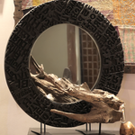 Ekaurr Artisan Wooden Emblem Round Mirror shown in styled setting, handcrafted 30-inch round mirror with dimensional black emblem frame for living room or entryway wall