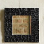 Ekaurr Artisan Wooden Emblem Square Mirror framed with black-finished vintage wooden emblem blocks featuring abstract letterforms and carved symbols, handcrafted heritage wall mirror