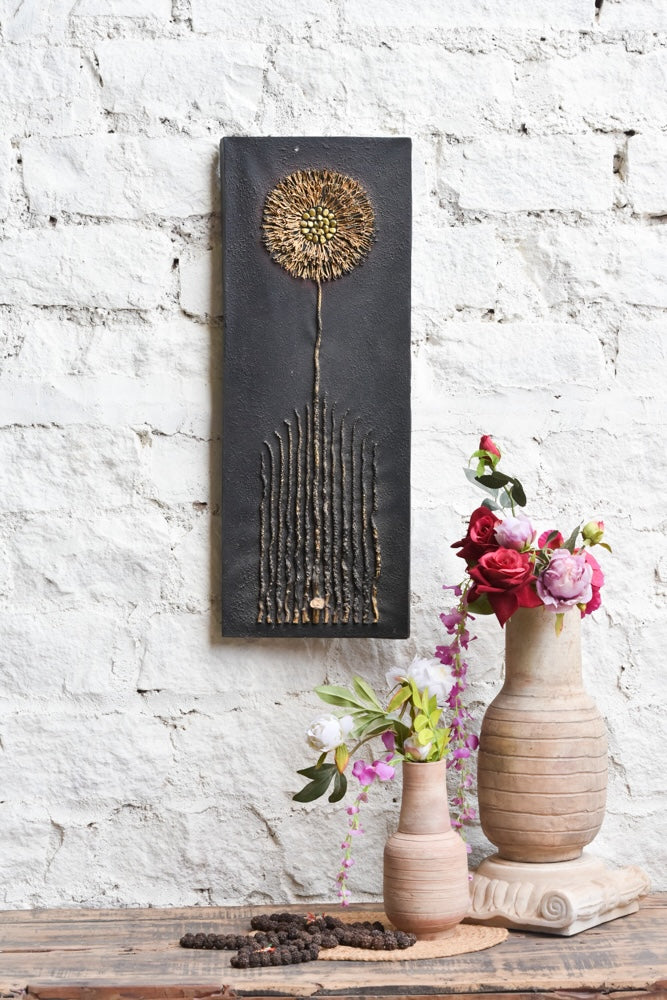 Ekaurr Bloom in Stillness mixed-media wall art of a dandelion-inspired bloom with golden textured detailing on a matte black base at 32x12 inches, handcrafted botanical home decor for modern rustic living rooms