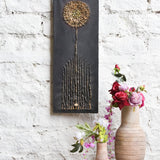 Ekaurr Bloom in Stillness mixed-media wall art of a dandelion-inspired bloom with golden textured detailing on a matte black base at 32x12 inches, handcrafted botanical home decor for modern rustic living rooms