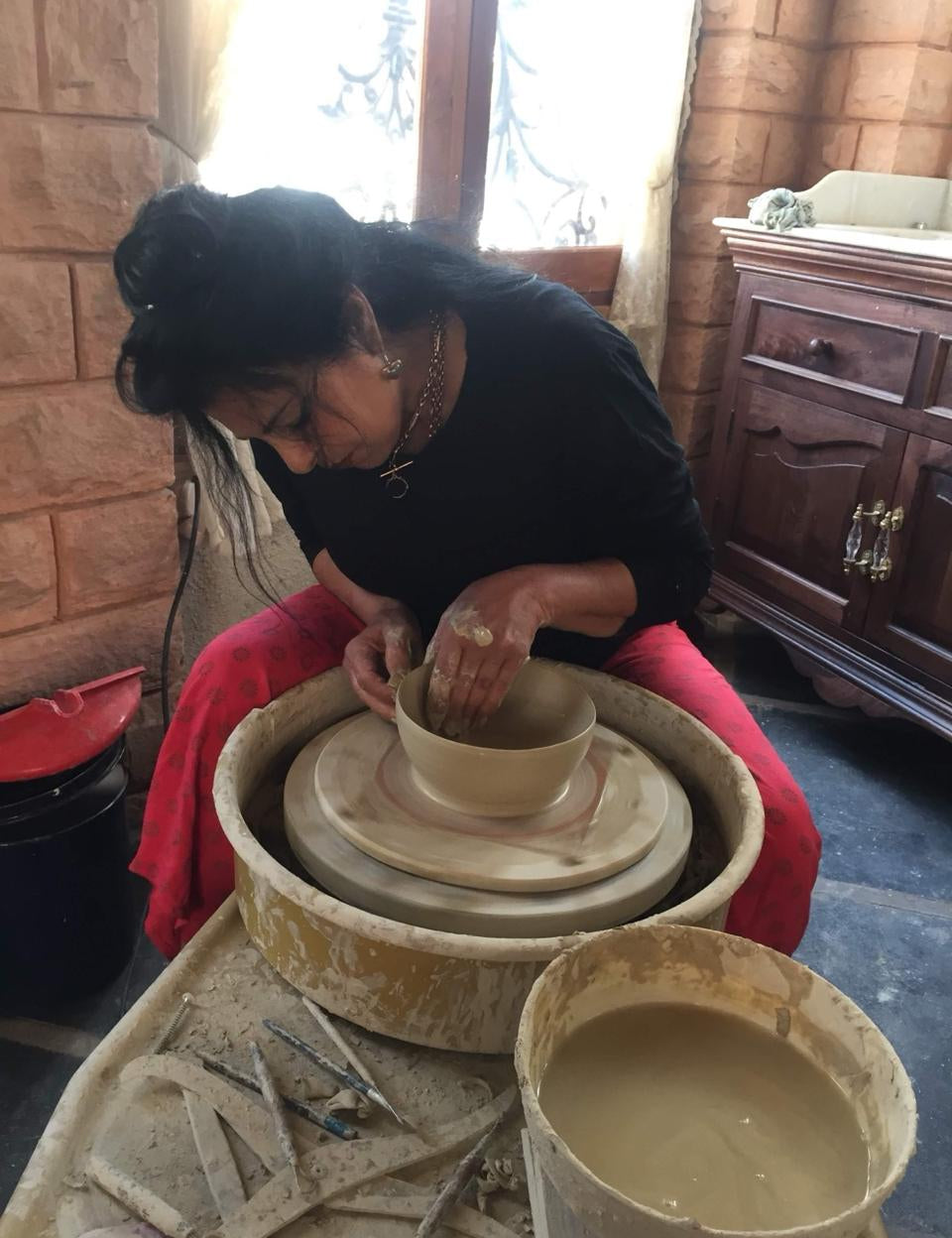 Ekaurr Ceramic Cactus from Liora's charity art collection displayed alongside other hand-glazed ceramic pieces, showing full artisan context