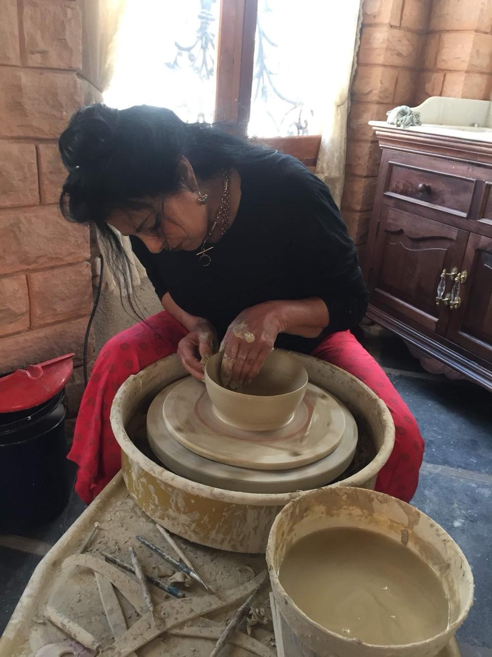 Ekaurr Ceramic Cactus from Liora's charity art collection displayed alongside other hand-glazed ceramic pieces, showing full artisan context