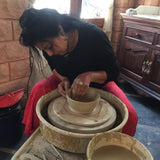 Ekaurr Ceramic Cactus from Liora's charity art collection displayed alongside other hand-glazed ceramic pieces, showing full artisan context