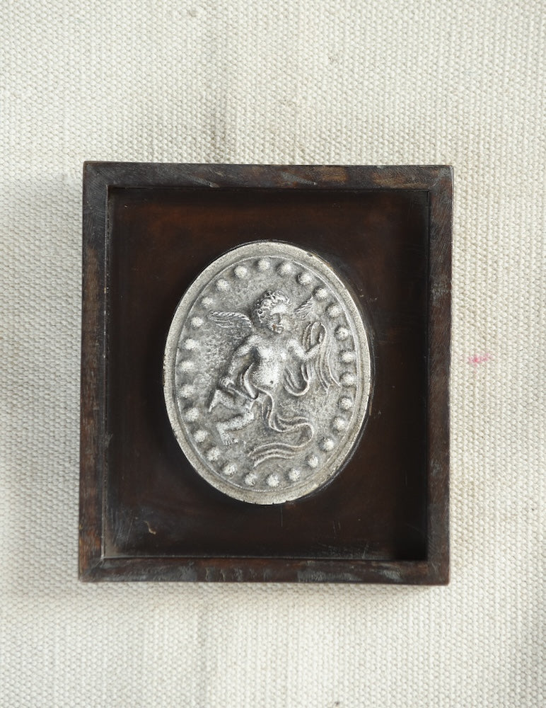 Ekaurr Ceramic Tile Wall Art – The Classical Cherub Medallion, embossed ceramic cherub motif framed in warm-toned wooden shadowbox, heritage-inspired decorative wall piece