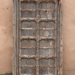 Ekaurr Dwaar Memoir antique salvaged Rajasthan teakwood door frame with hand-carved floral motifs and rusted iron accents, architectural heritage wall art and statement décor