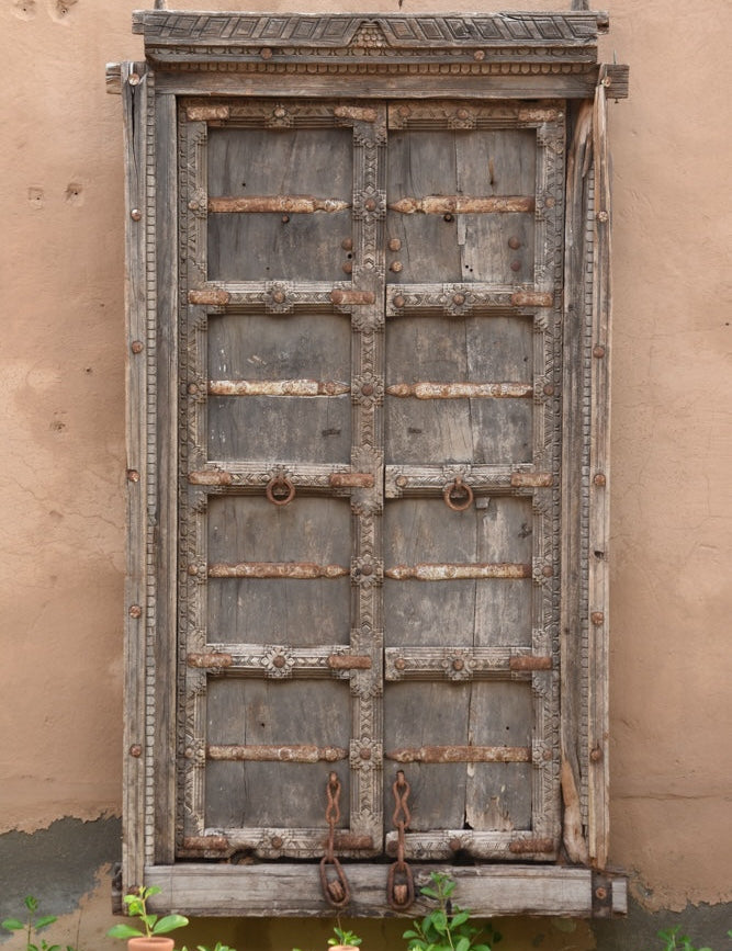 Ekaurr Dwaar Memoir antique salvaged Rajasthan teakwood door frame with hand-carved floral motifs and rusted iron accents, architectural heritage wall art and statement décor