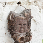 Angled view of Ekaurr Elder Spirit wall mask showing deep-carved facial features and antique patina finish