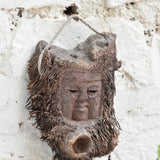 Angled view of Ekaurr Elder Spirit wall mask showing deep-carved facial features and antique patina finish