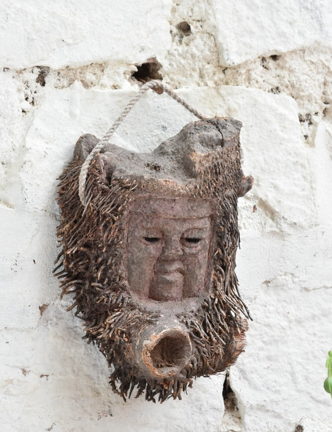 Angled view of Ekaurr Elder Spirit wall mask showing deep-carved facial features and antique patina finish