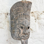 Ekaurr Fierce Protector decorative mask displayed on a wall, showcasing its powerful carved features and deep earthy tones