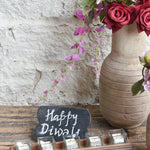 Ekaurr Flame Gift Set curated artisan gift of an emblem chalkboard five glass tealight cups with candles in aluminium containers a handcrafted wooden tray a muslin pouch of 24 decorative stones and greeting card at Rs.5100, thoughtful sustainable gifting for home ambience and festive occasions