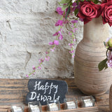 Ekaurr Flame Gift Set curated artisan gift of an emblem chalkboard five glass tealight cups with candles in aluminium containers a handcrafted wooden tray a muslin pouch of 24 decorative stones and greeting card at Rs.5100, thoughtful sustainable gifting for home ambience and festive occasions