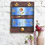 Ekaurr Golden Bloom on Blue mixed-media wall art of a radiant flower rising against a vivid blue ground with embossed swirling motifs and metallic gold leaf detailing at 24x32 inches, handcrafted home decor for entryways and living rooms