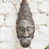 Ekaurr Guardian Spirit Mask close detail showing hand-carved headdress and facial features in aged natural wood