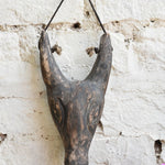 Close-up of Ekaurr Horned Sentinel wall mask showing hand-carved horn detailing and textured surface with aged finish