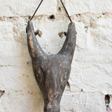Close-up of Ekaurr Horned Sentinel wall mask showing hand-carved horn detailing and textured surface with aged finish