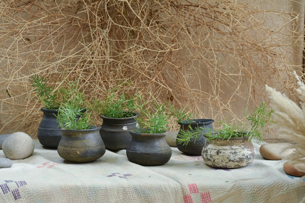 Ekaurr The Matka Tree overhead view showing the stone ring base and arrangement of 100 handcrafted vintage Koyla terracotta pots in a natural outdoor setting