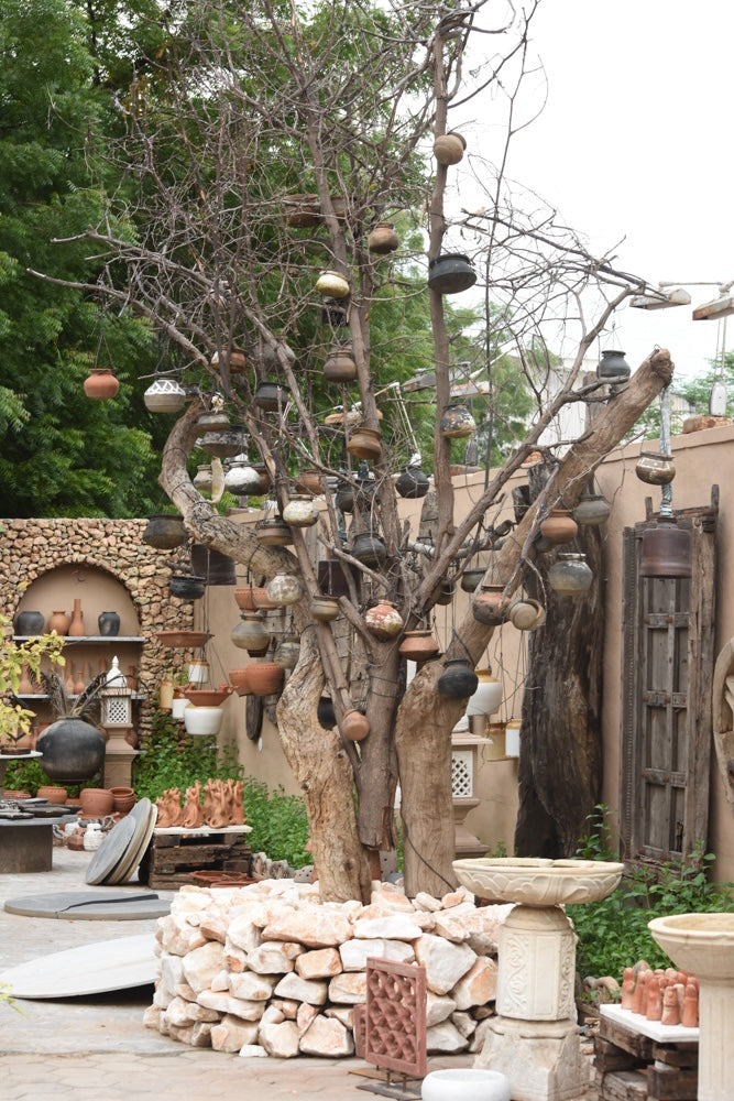 Ekaurr The Matka Tree living tree planted in a stone ring base surrounded by 100 handmade terracotta pots, one-of-a-kind sustainable botanical installation