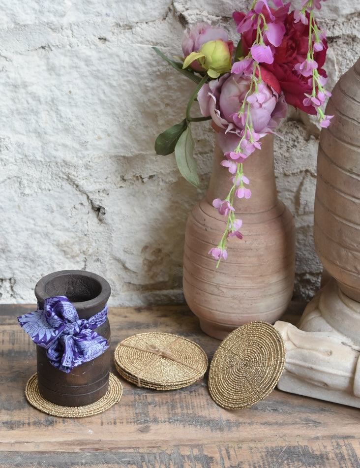 Ekaurr Morning Elegance Gift Set curated artisan gift set of four hand-beaded gold weave coasters paired with a reclaimed wood pot adorned with a fabric bow and complimentary greeting card, elegant sustainable gifting for home and table styling