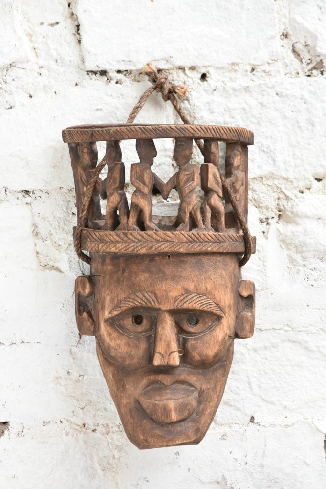 Ekaurr Peace Maker Tribal Bond Mask detail view highlighting hand-chiselled tribal figures and natural wood character