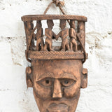 Ekaurr Peace Maker Tribal Bond Mask detail view highlighting hand-chiselled tribal figures and natural wood character