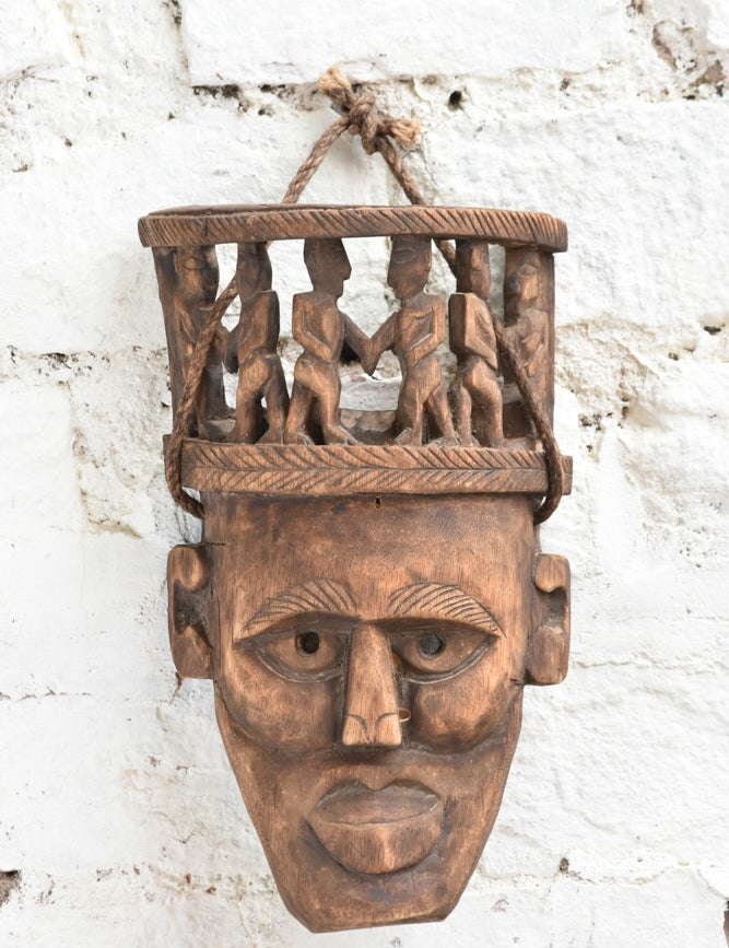 Ekaurr Peace Maker Tribal Bond Mask detail view highlighting hand-chiselled tribal figures and natural wood character
