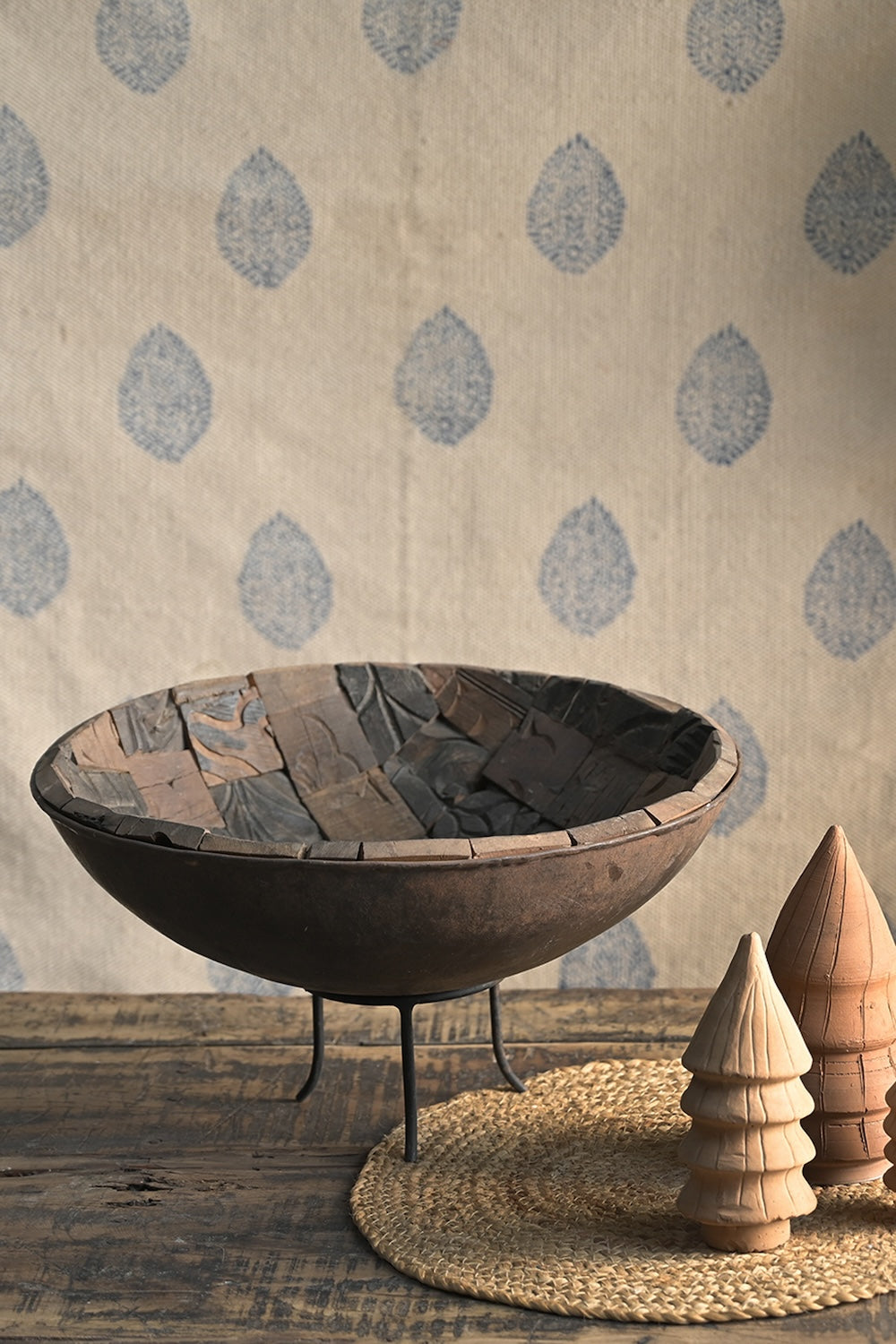 Close-up detail of Ekaurr iron bowl interior lined with antique printing blocks featuring carved artisan textures