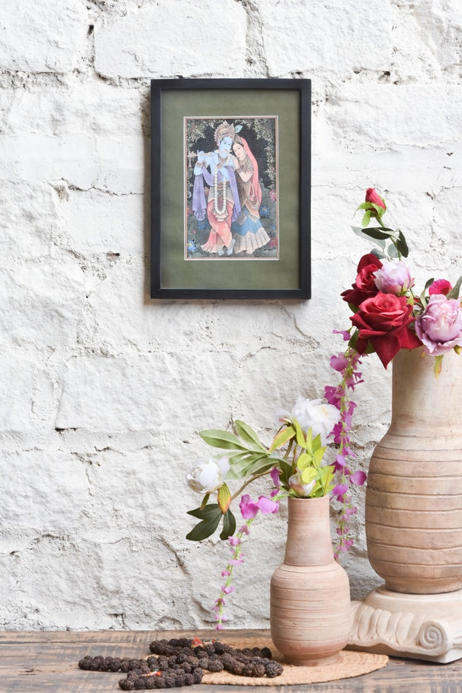 Ekaurr Radha Krishna Eternal Melody framed wall art depicting Radha and Krishna in a devotional composition with Krishna playing the flute set in a black frame with olive mount, spiritual home decor for altars and living rooms