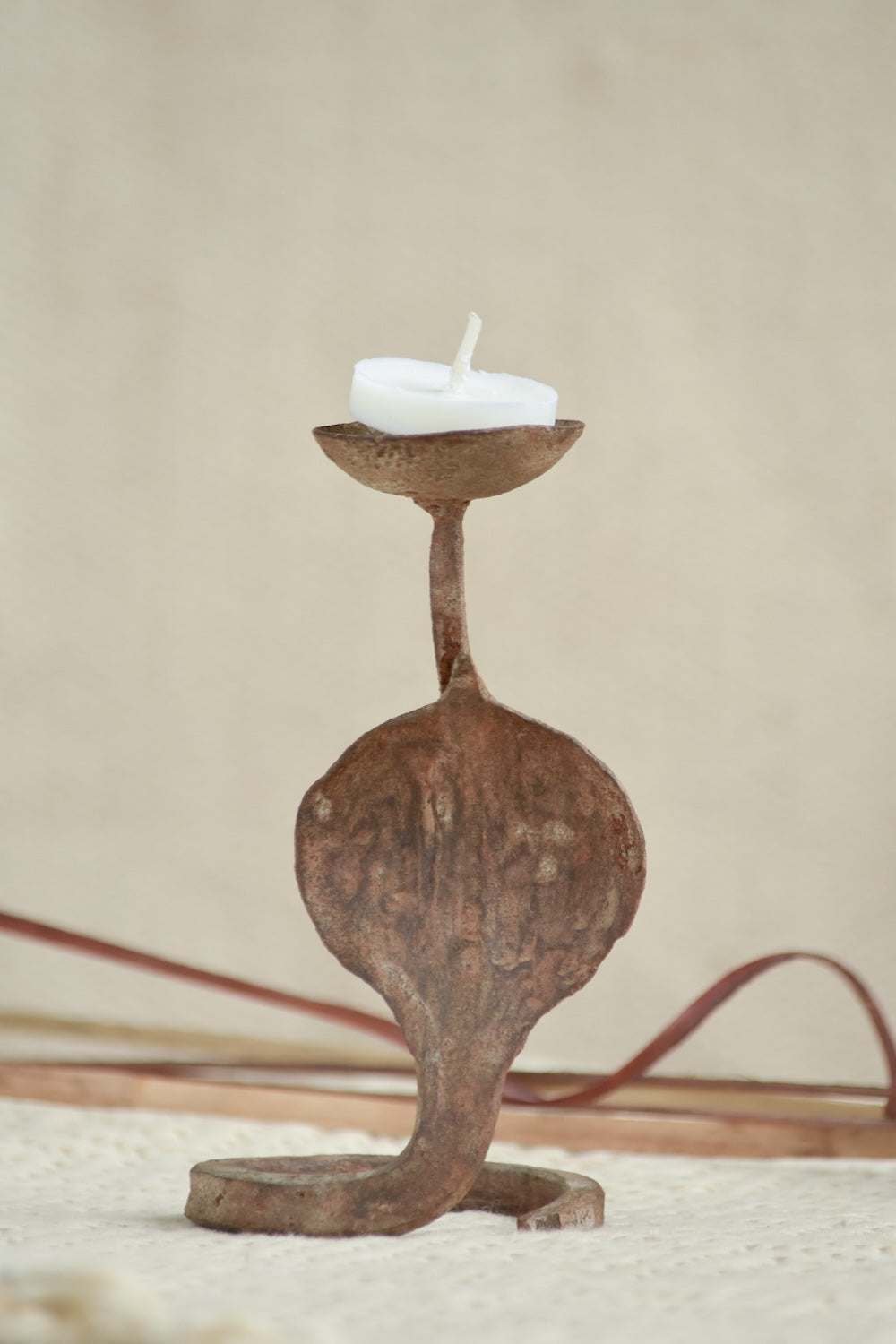 Ekaurr Rustic Snake Iron Candles styled with lit candles showing the snake form silhouette in warm candlelight against a home setting
