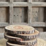 Ekaurr Rustic Tree Ring Platter round natural wood cross-section with exposed tree ring grain and raw bark edge, handcrafted wood serving base or table centrepiece available individually or in sets