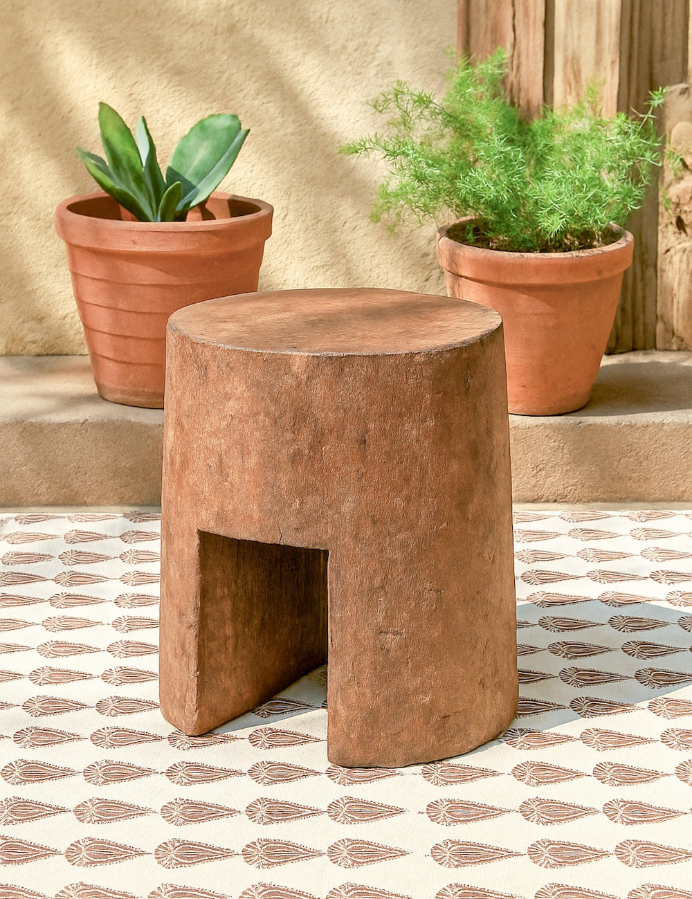 Ekaurr Solid Wood Chiseled Stool hand-carved from reclaimed wood with bold monolithic form, round top and arched base for rustic or contemporary interiors