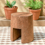 Ekaurr Solid Wood Chiseled Stool hand-carved from reclaimed wood with bold monolithic form, round top and arched base for rustic or contemporary interiors