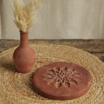 Ekaurr Terracotta Flower Design Riser handcrafted clay display stand with raised floral motif surface carving, earthy artisan pedestal for small sculptures candles or home decor accents