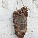 Ekaurr The Flame Keeper Mask shown at angle revealing carved bark-textured surface and raw natural wood tones, ancient elemental guardian wall décor piece