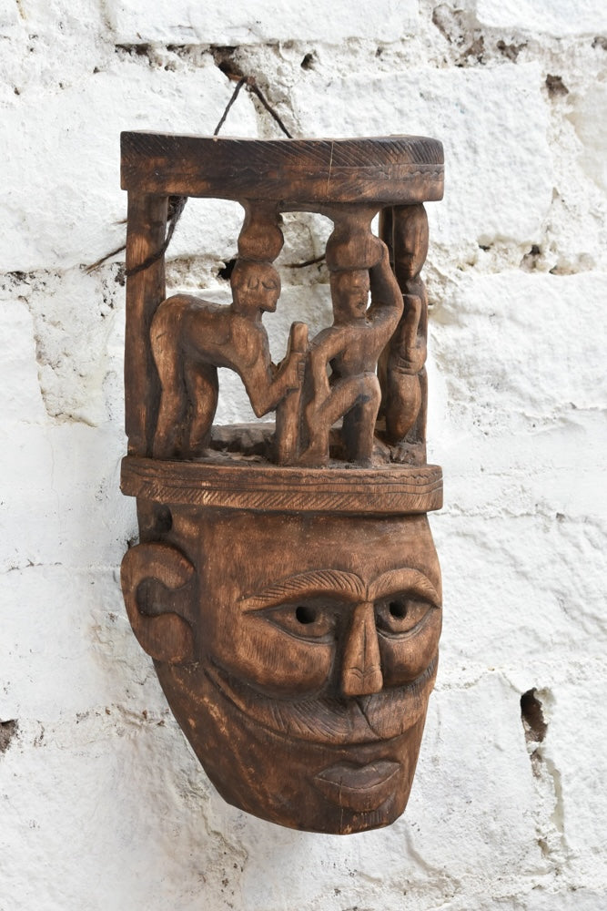 Ekaurr Tribal Crown Mask detail showing miniature hand-carved village figures on crown and expressive facial carving in aged reclaimed wood