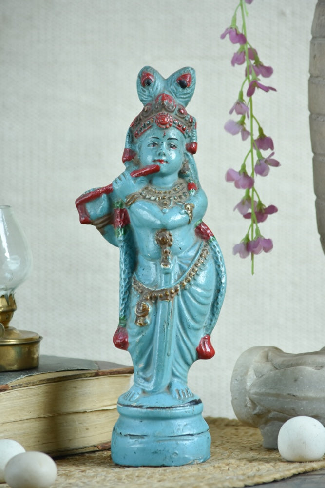 Ekaurr Turquoise Melody Krishna hand-painted idol in vibrant turquoise with flute and peacock feather crown beneath serpent hood, traditional devotional figurine for pooja rooms and home decor