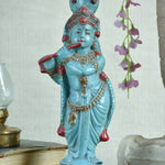Ekaurr Turquoise Melody Krishna hand-painted idol in vibrant turquoise with flute and peacock feather crown beneath serpent hood, traditional devotional figurine for pooja rooms and home decor