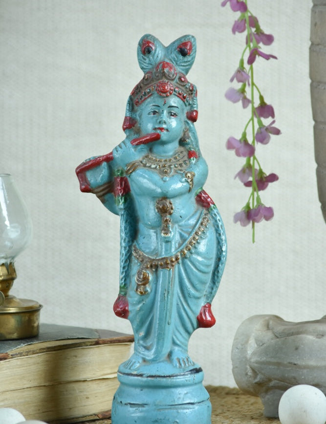 Ekaurr Turquoise Melody Krishna hand-painted idol in vibrant turquoise with flute and peacock feather crown beneath serpent hood, traditional devotional figurine for pooja rooms and home decor