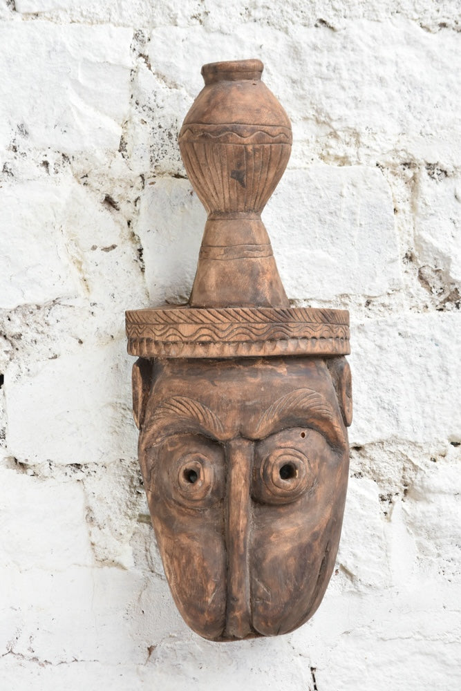 Ekaurr The Water Bearer Mask close-up showing intricate hand-carved facial details and earthy texture of vintage reclaimed wood
