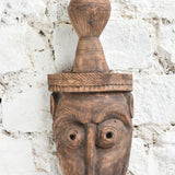 Ekaurr The Water Bearer Mask close-up showing intricate hand-carved facial details and earthy texture of vintage reclaimed wood