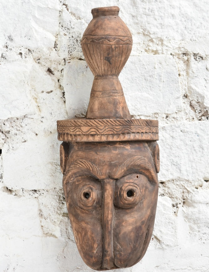 Ekaurr The Water Bearer Mask close-up showing intricate hand-carved facial details and earthy texture of vintage reclaimed wood